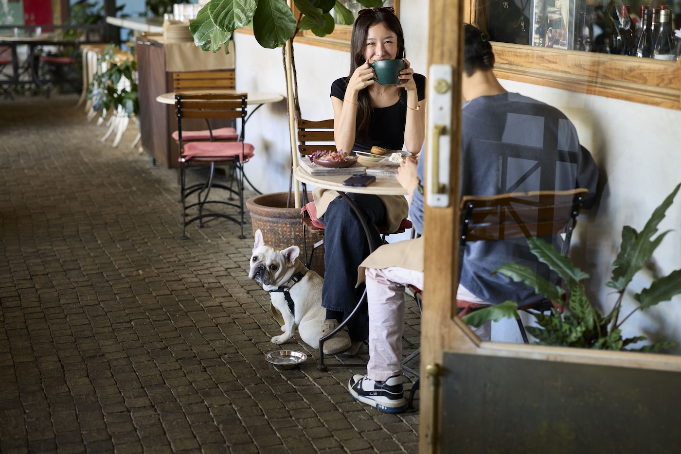 Couple with dog having brunch at a table in the outdoor area of Manuela.