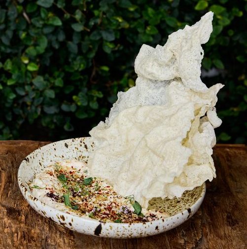 Smoked albacore dip served with a Carolina gold rice crackers on a textured plate