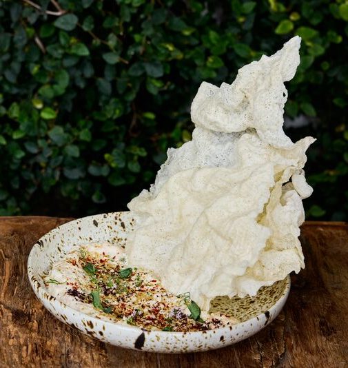Smoked albacore dip served with a Carolina gold rice crackers on a textured plate