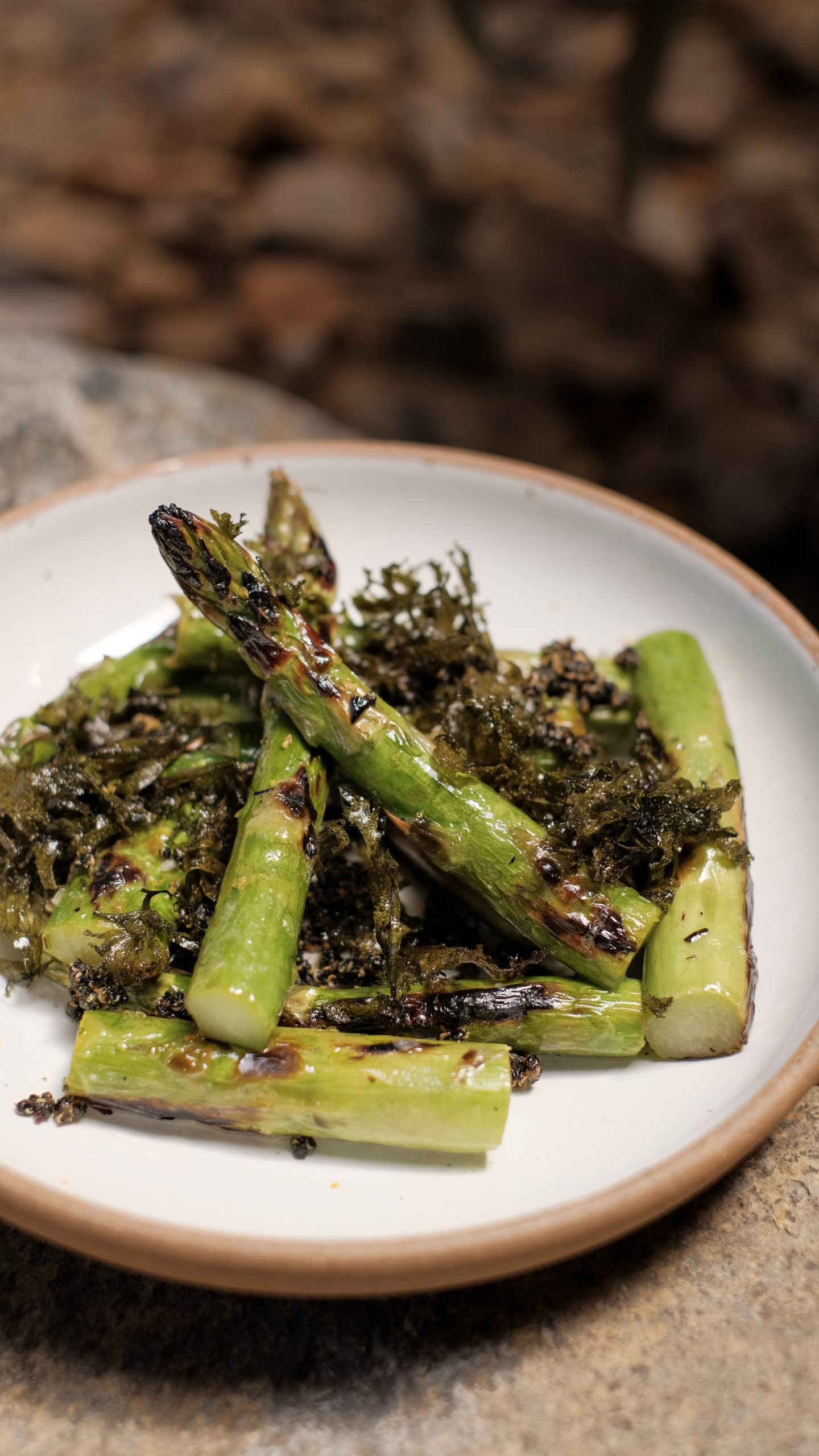 Pieces of grilled green asparagus on a white plate.