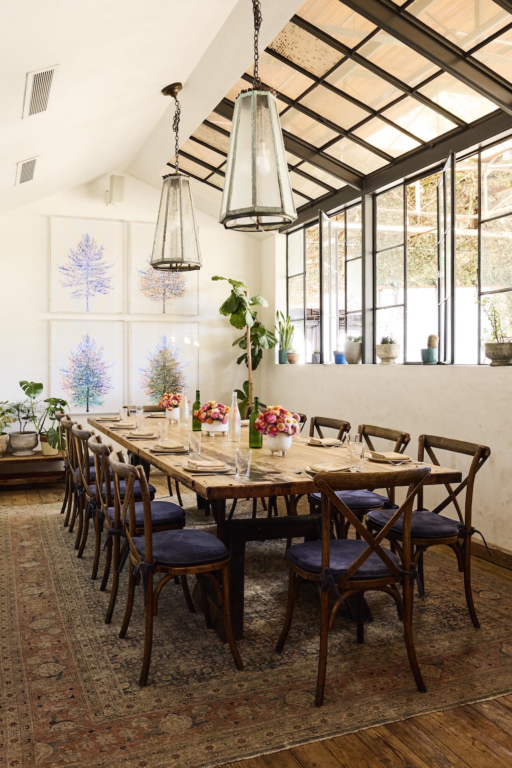 The interior of a private dining room with windows and long wooden table set for dining.
