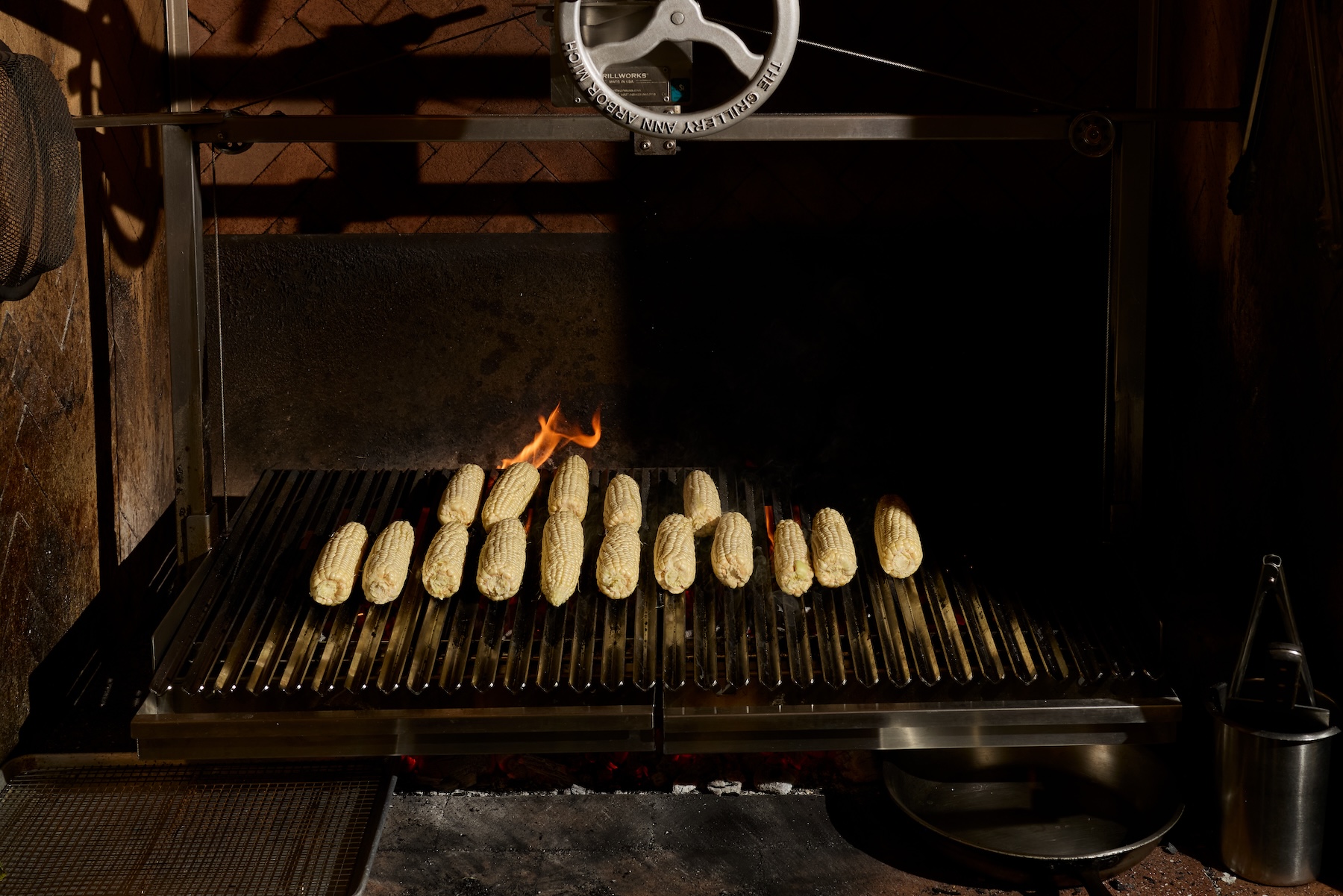 An indoor grill in Manuela's kitchen with fresh cobs of corn cooking on the grates.